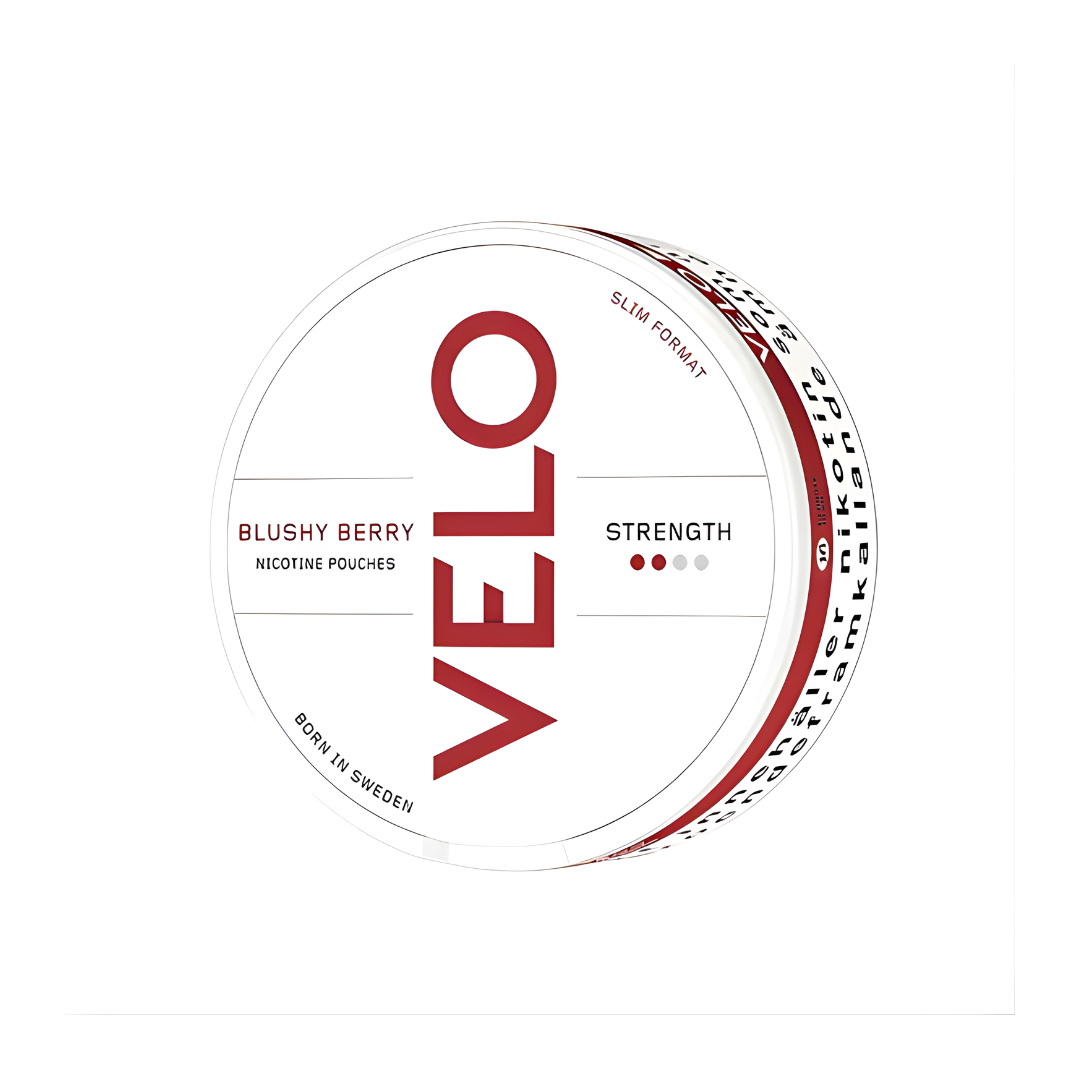 Detail close-up of the Velo Blushy Berry snus can showcasing its circular shape, red and white colors, and brand logo.