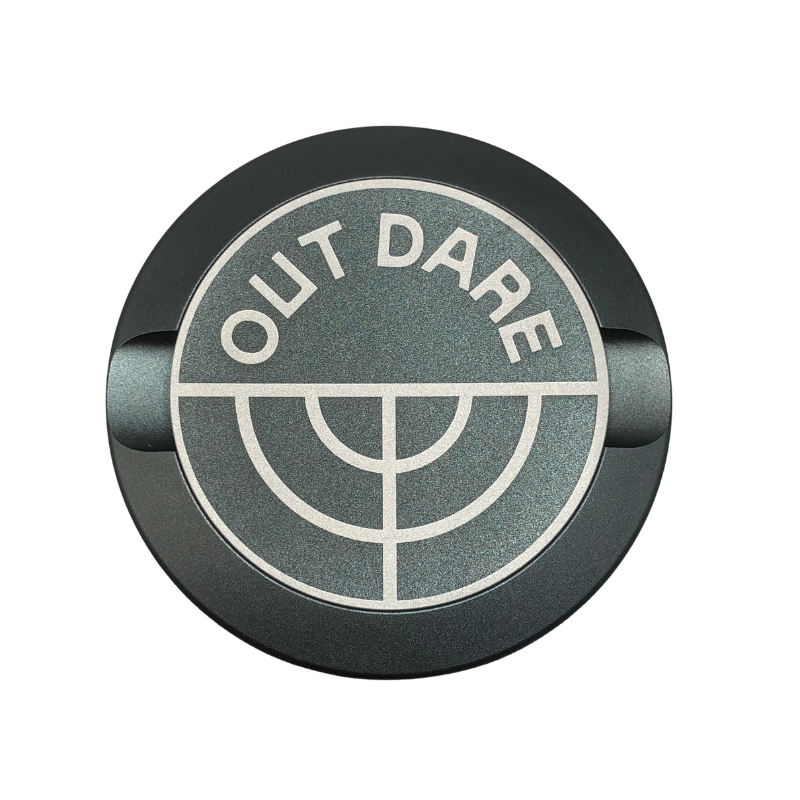 Detail close-up of the silver metal can showcasing a circular logo with text and graphic design.